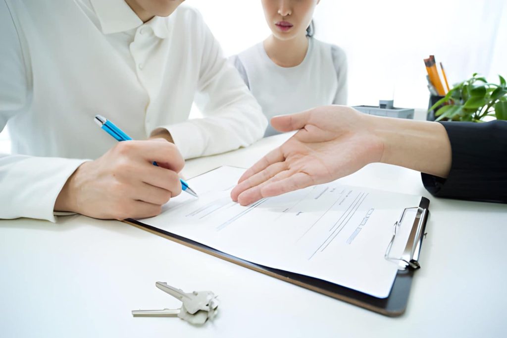 Home watch Palm City professionals signing agreement with keys on table in office setting
