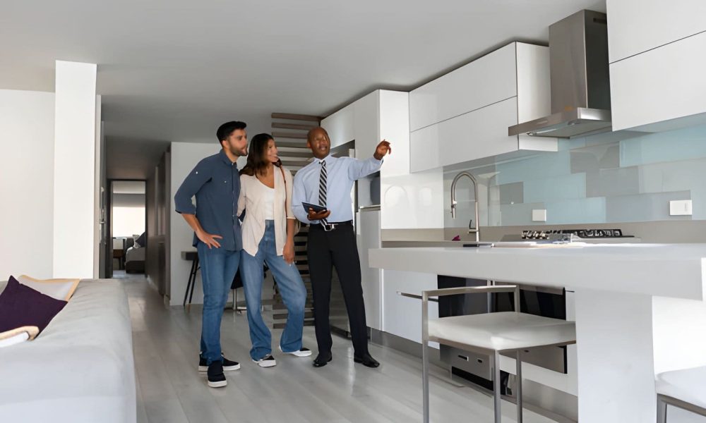 Property watch Palm City professional showing modern kitchen features to clients during home inspection.